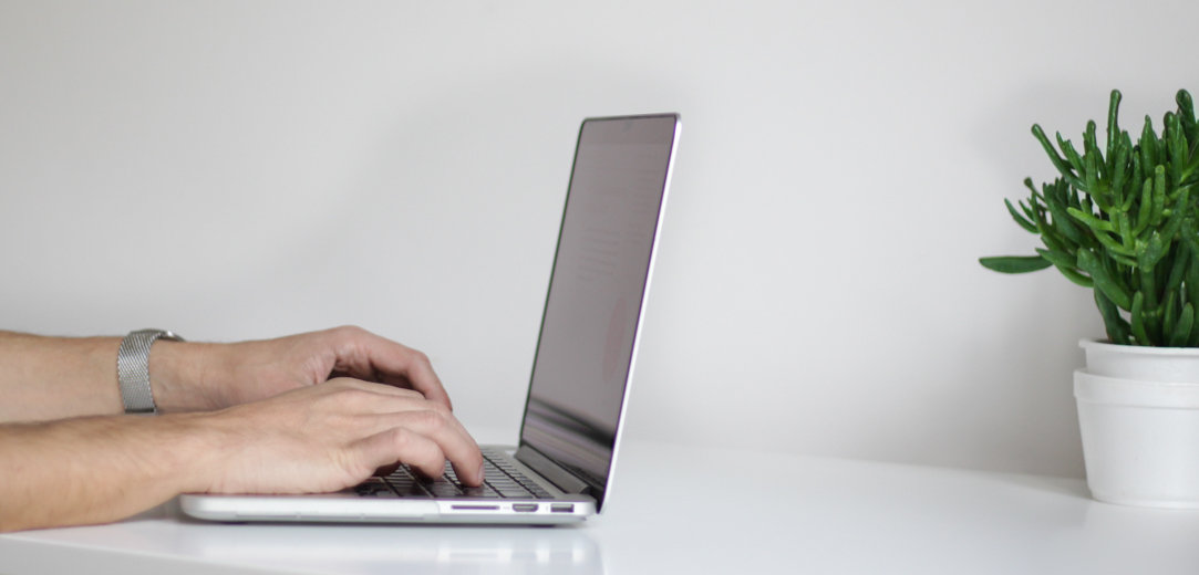 Hands typing on a Windows laptop