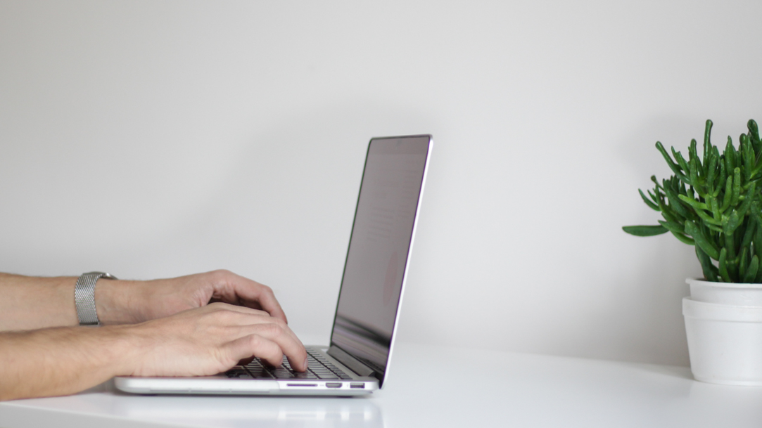 Hands typing on a Windows laptop