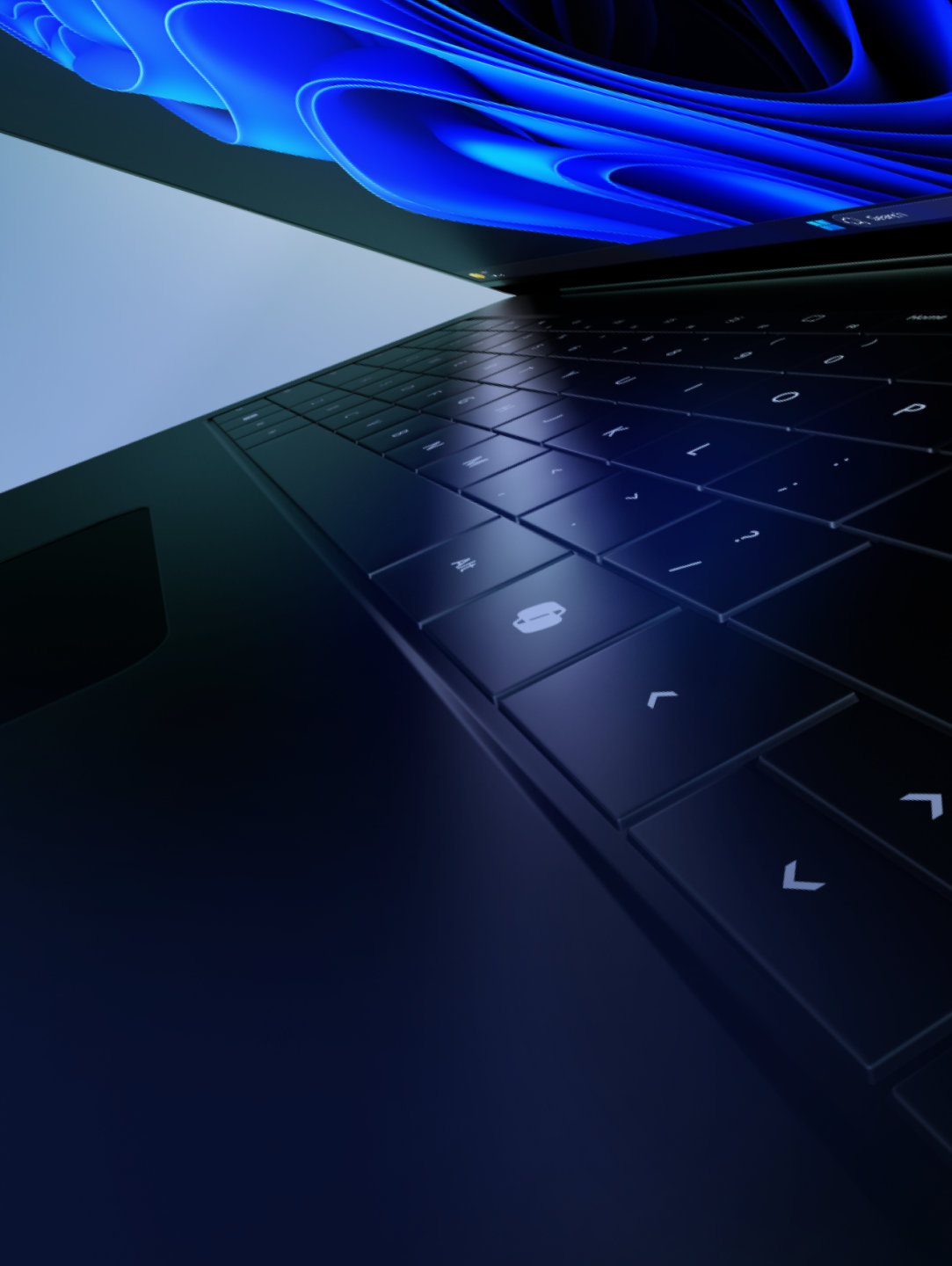 A laptop in black, open and tipped dramatically on its side, with a partial keyboard and blue bloom image visible