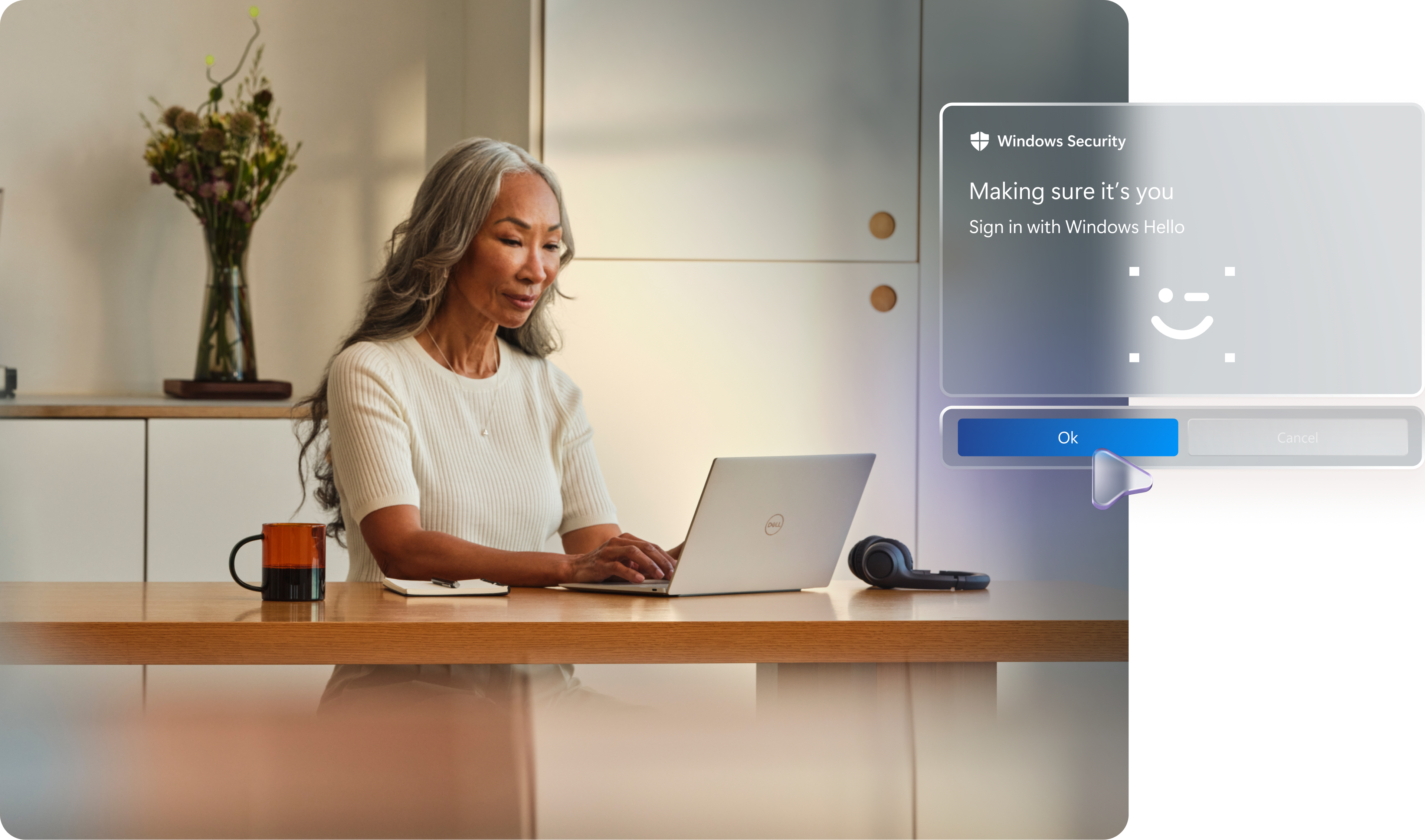 Person sitting at a work counter with an open Windows 11 Pro device, wireless headphones sitting by the PC, a notepad, a coffee mug, and a vase of flowers in the background, with conceptual images showing secure sign in with Windows