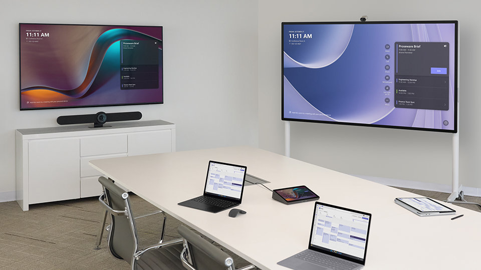 An image showing an office room with a wall mounted Hub 3 50-inch, and a Hub 3 85-inch on a stand