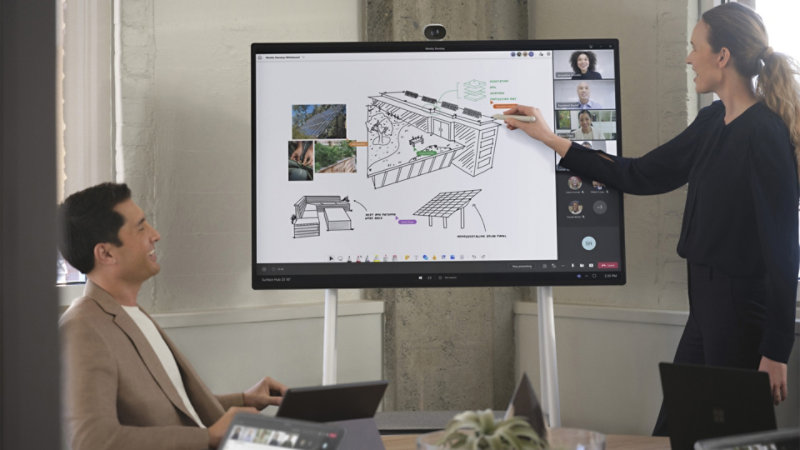 Teammedlemmar samarbetar virtuellt och på plats i ett PowerPoint Live-dokument