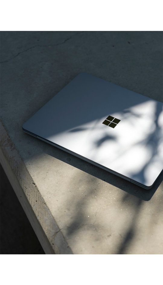 Bovenaanzicht van gesloten Surface Laptop Go 2 in een stedelijke buitenomgeving