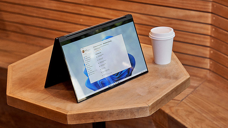Bærbar PC plassert på et bord med en kaffekopp ved siden av