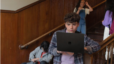 Male and female students gathered in a stairwell using back-to-school tech
