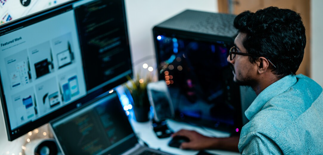 Man in a blue dress shirt using a computer at a desk