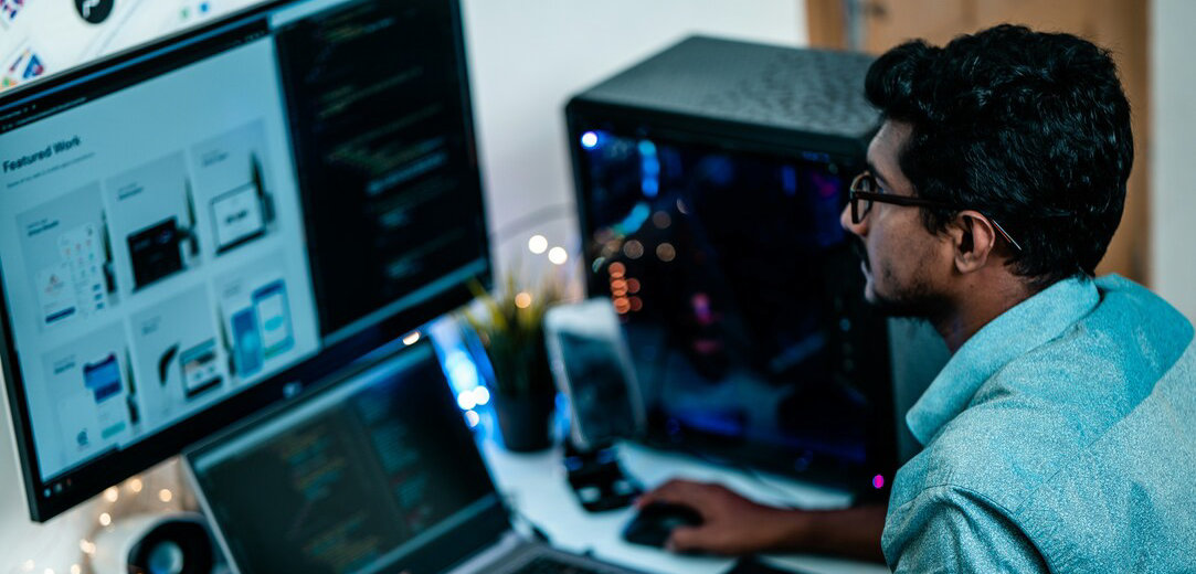 Man in a blue dress shirt using a computer at a desk