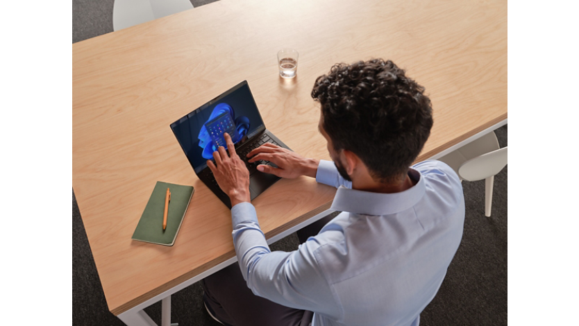 Una persona tocando la pantalla de un dispositivo Windows Surface Pro en modo portátil