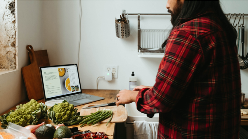 Man standing in front of fresh produce and laptop screen