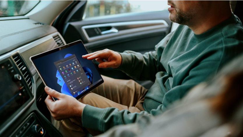 man using Surface tablet in passenger seat of car