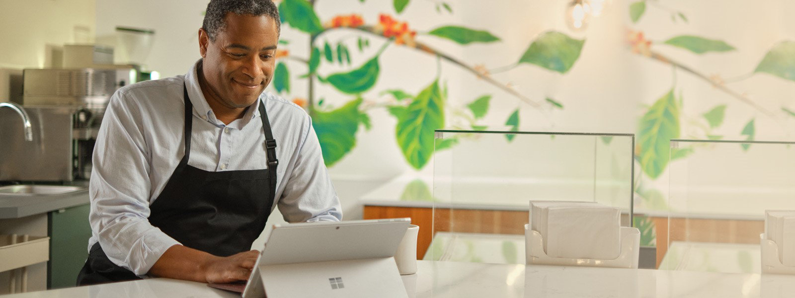 Mann arbeitet mit einem Surface Pro 7+ in seinem Restaurant