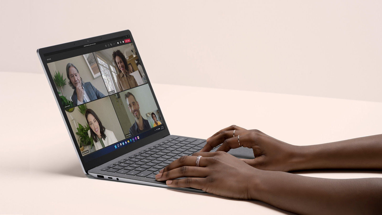 Microsoft Teams diperhatikan pada skrin peranti Surface Laptop 4 dengan tangan seseorang diletakkan di atas papan kekunci