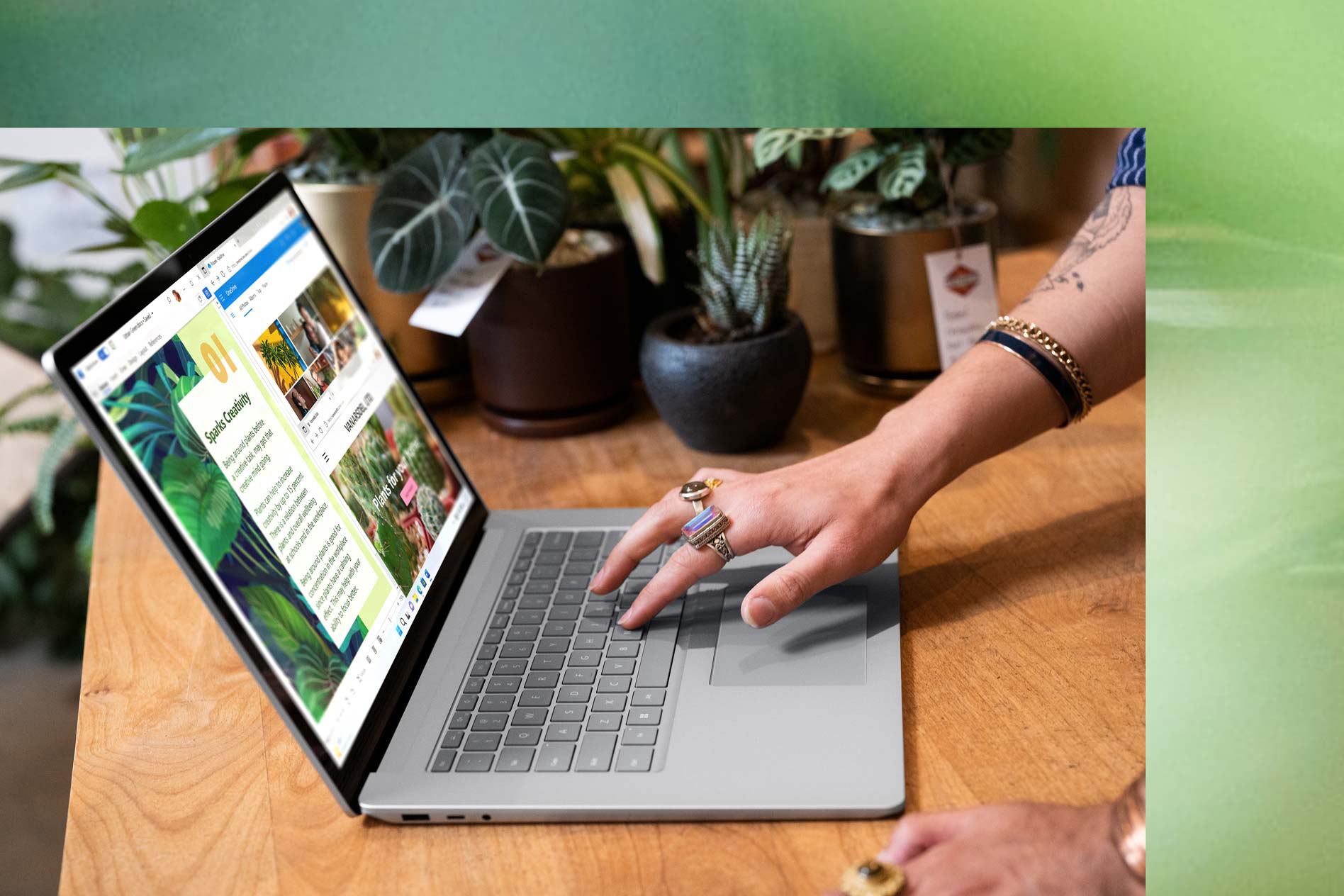 A platinum Surface Laptop 5 is shown from a side view where a person works using Snap Assist on screen.