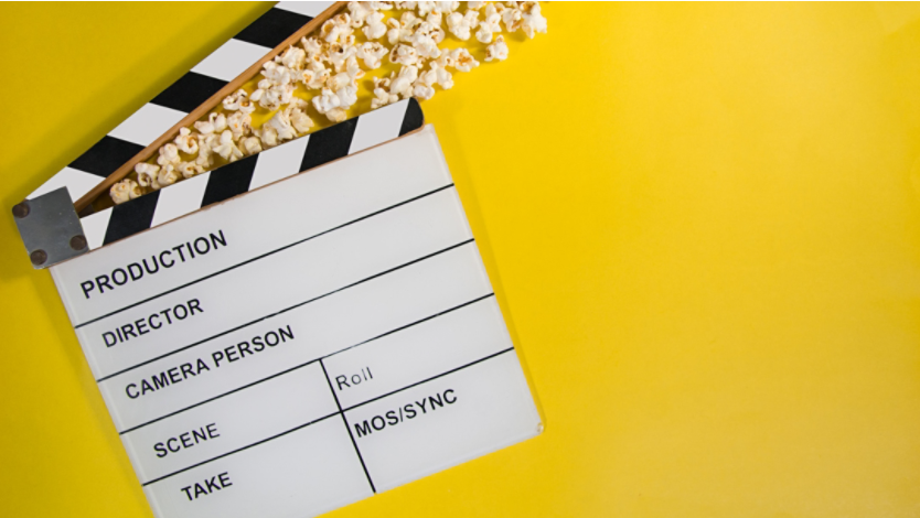Movie clapperboard with popcorn