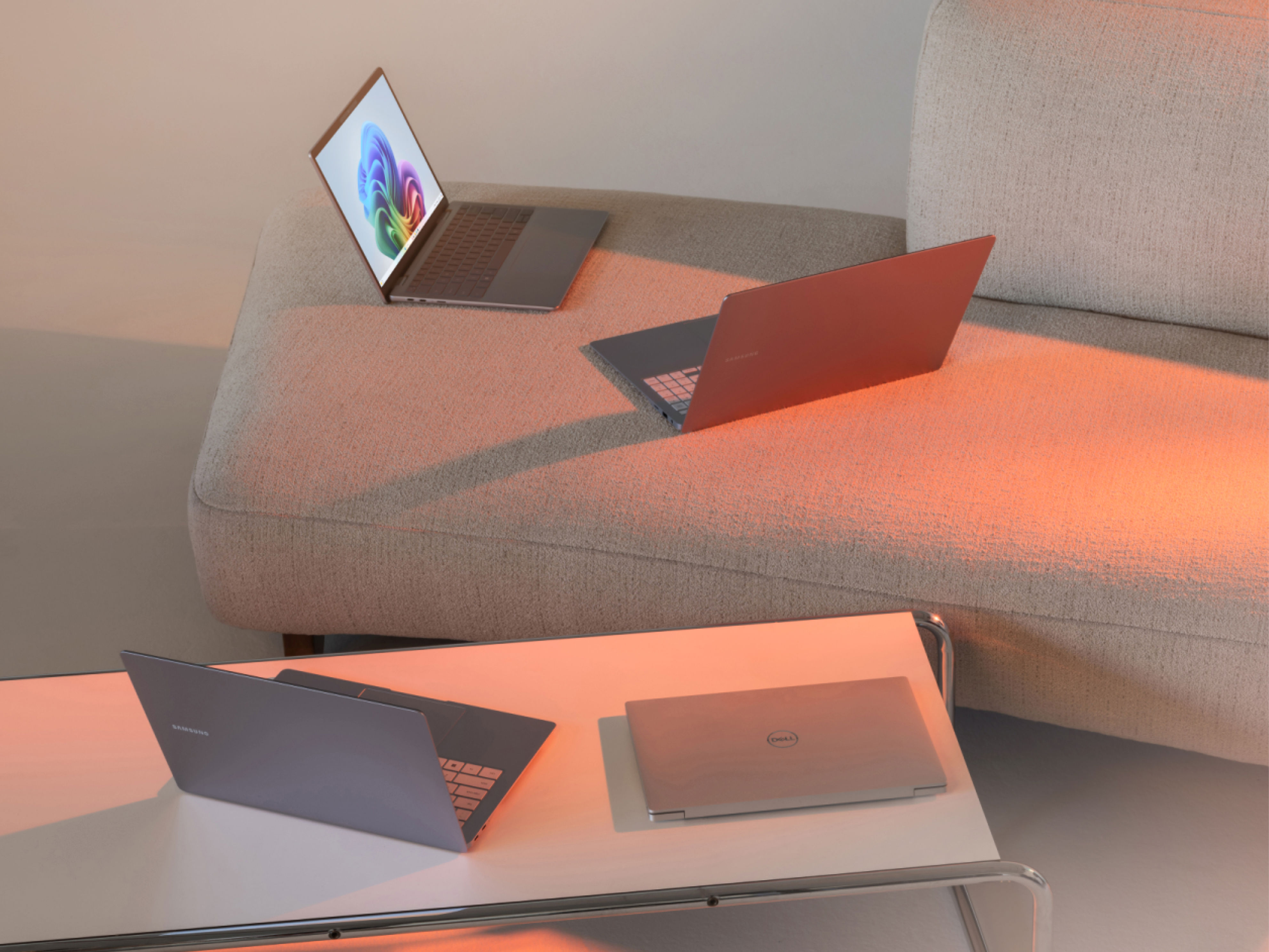 Flere laptops, der står på et kaffebord og en sofa
