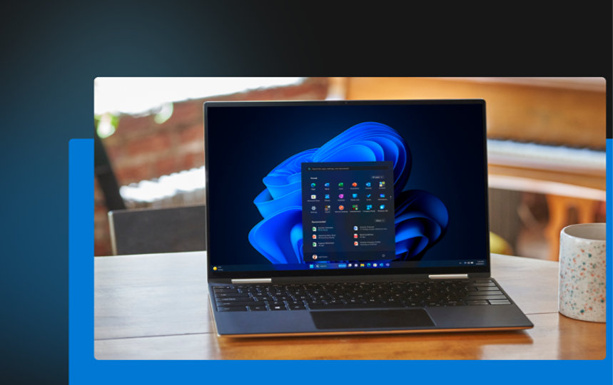 Offener Laptop mit Windows 11-Startbildschirm neben einer Tasse.