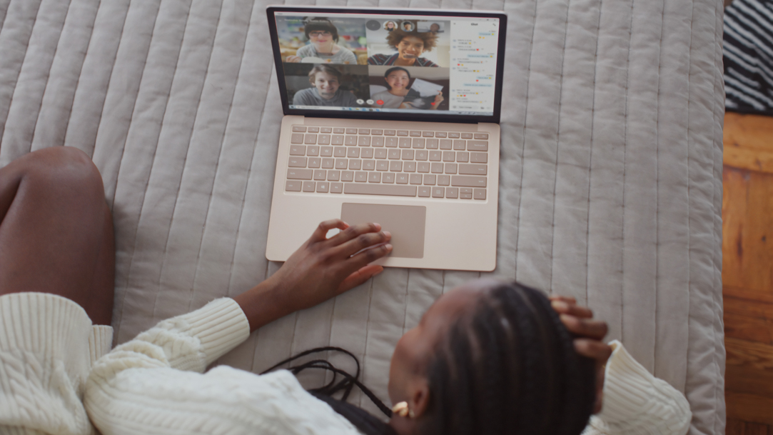 Person in a white, long sleeve shirt using Surface laptop