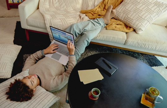 Person laying down while holding a laptop that has Microsoft Edge open