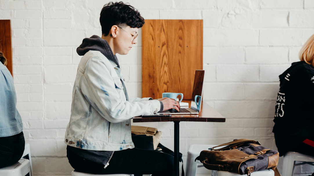 Person sitting at a table using a laptop