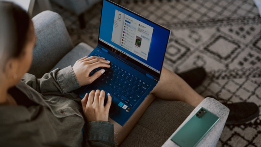 Person sitting on couch using Windows laptop