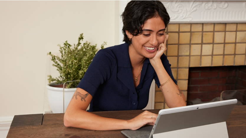 Person smiling while viewing their Surface device
