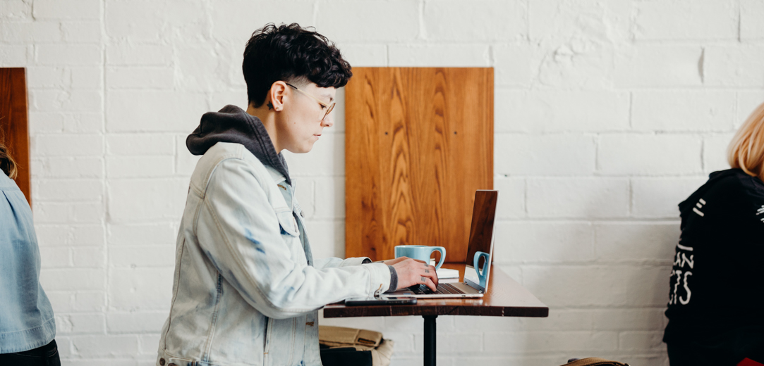 Person typing on a laptop in a cafe