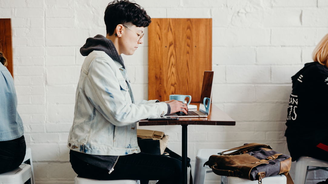  Person typing on a laptop in a cafe