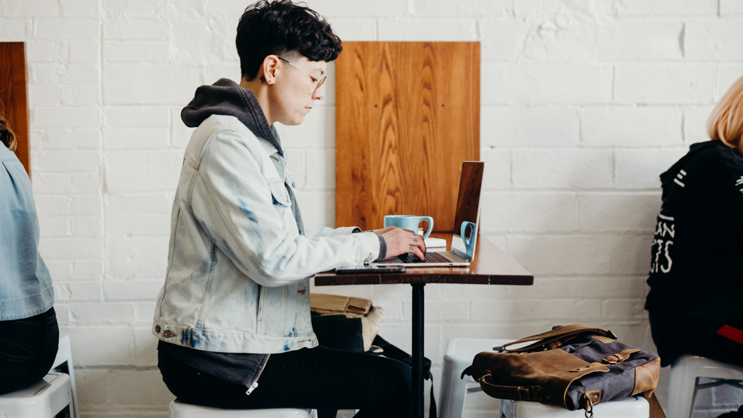 Person typing on a laptop in a café