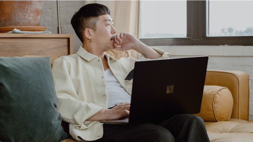 Person using a Surface laptop while looking out their window