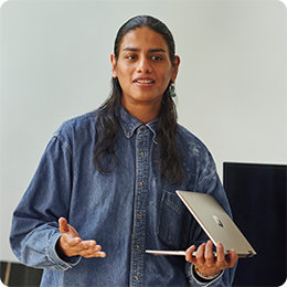 Person with long brown hair holding a PC