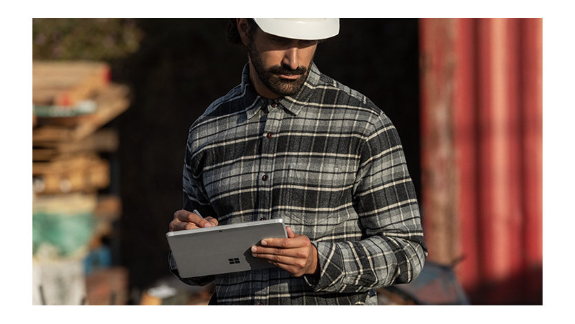 Ein Arbeiter vor Ort schreibt mit dem Surface Pen auf seinem Surface Go 2 im Tablet-Modus
