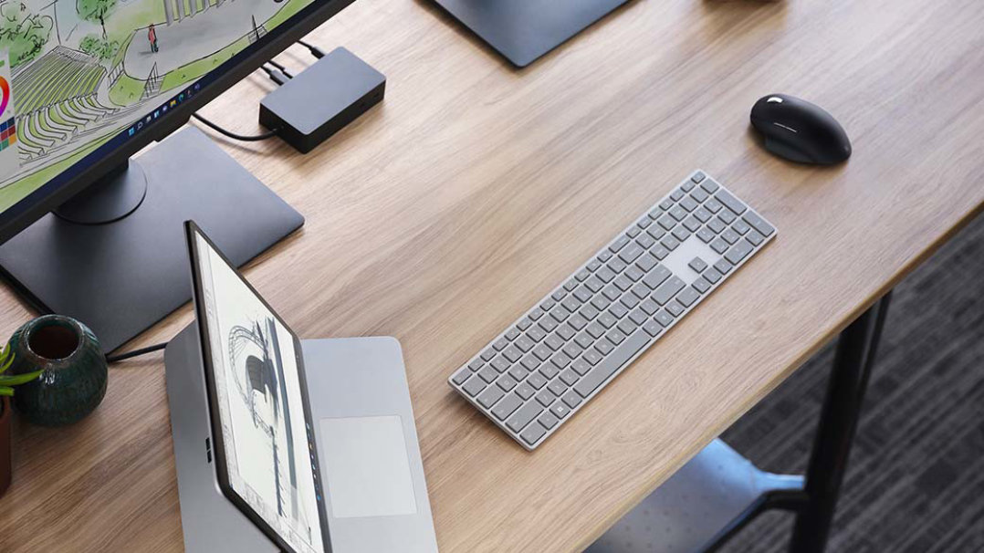 Surface Laptop Studio พร้อมอุปกรณ์เสริมต่าง ๆ บนโต๊ะสำนักงาน