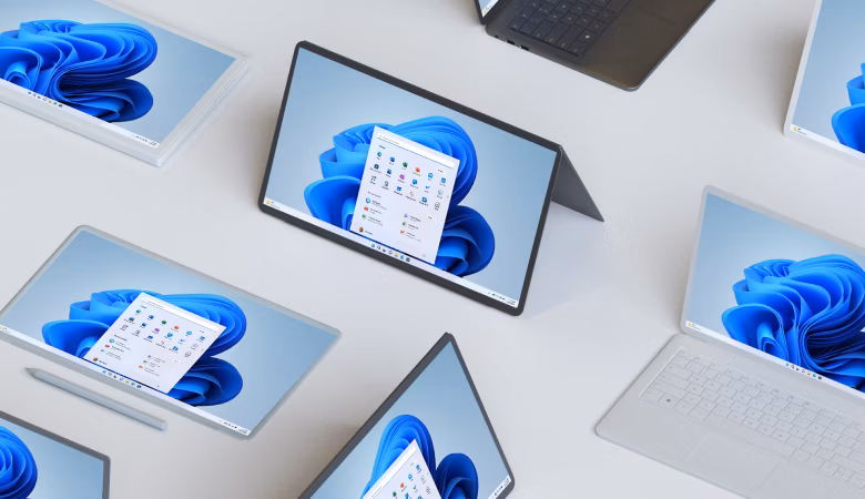 Several devices with Windows 11 bloom on screen sitting on a platform