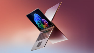 Silver laptops showing the Copilot+ PC bloom on the screen