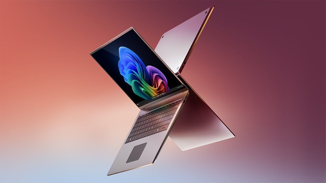 Silver laptops showing the Copilot+ PC bloom on the screen