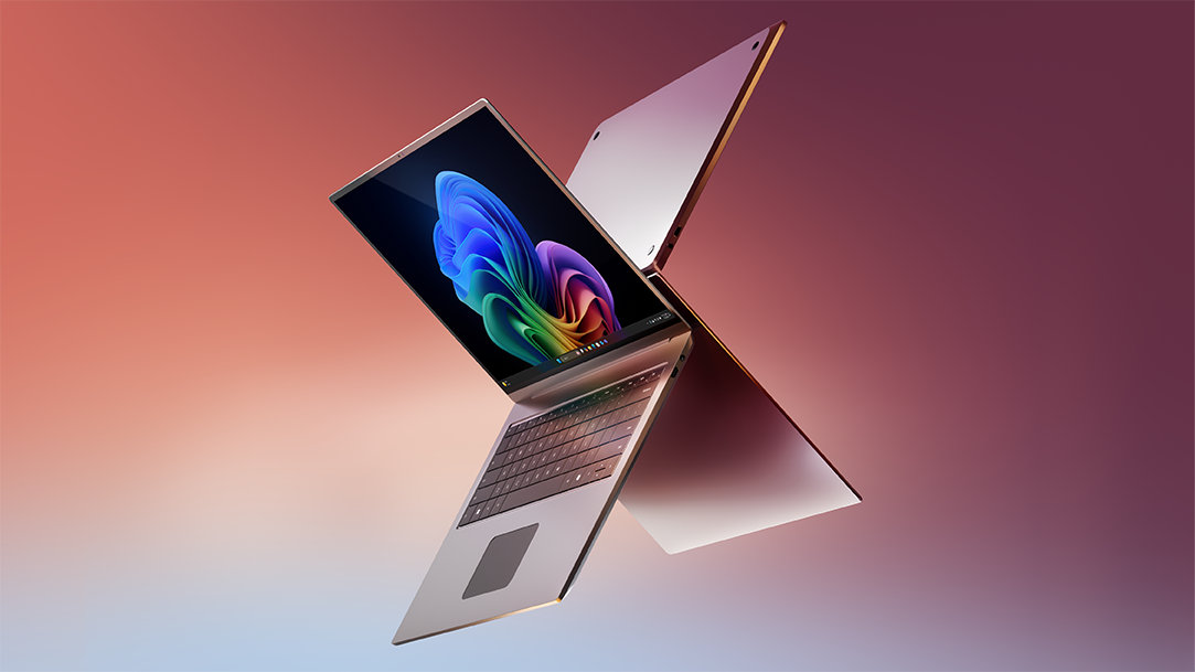 Silver laptops showing the Copilot+ PC bloom on the screen