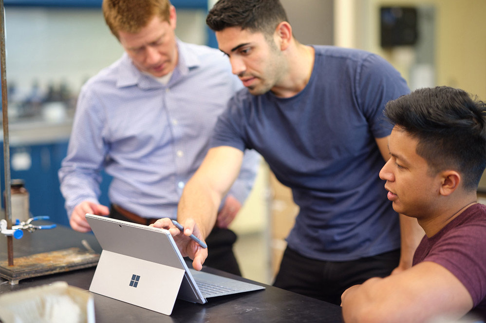 Schüler in einem Klassenzimmer für Naturwissenschaften arbeiten mit einem Surface Go 2 zusammen