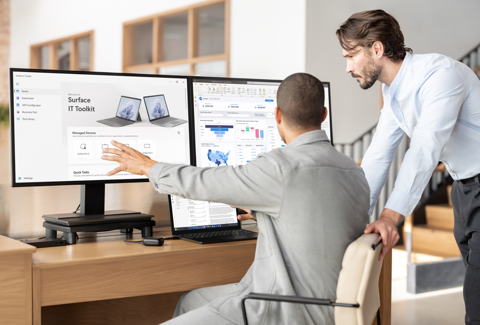 رجلان يجلسان على مكتب ويستخدمان شاشة كمبيوتر