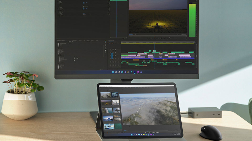 Surface Laptop Studio en mode station d’accueil sur un bureau, connecté à un écran externe et positionné derrière un Stylet Surface Slim Pen 2