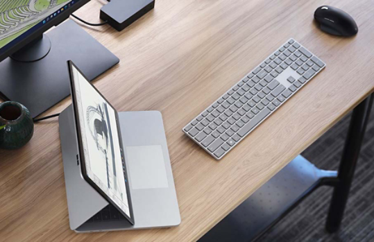 Surface Laptop Studio sur un bureau entouré de divers accessoires