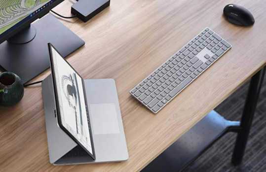 Surface Laptop Studio is observed with various accessories on an office desk