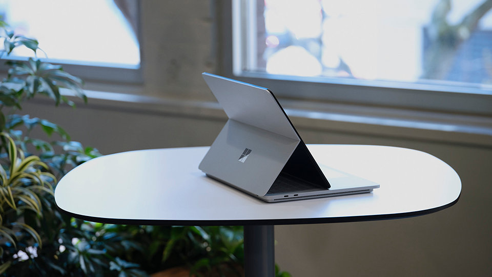 Surface Laptop Studio is shown on an office desk, not plugged into a power source