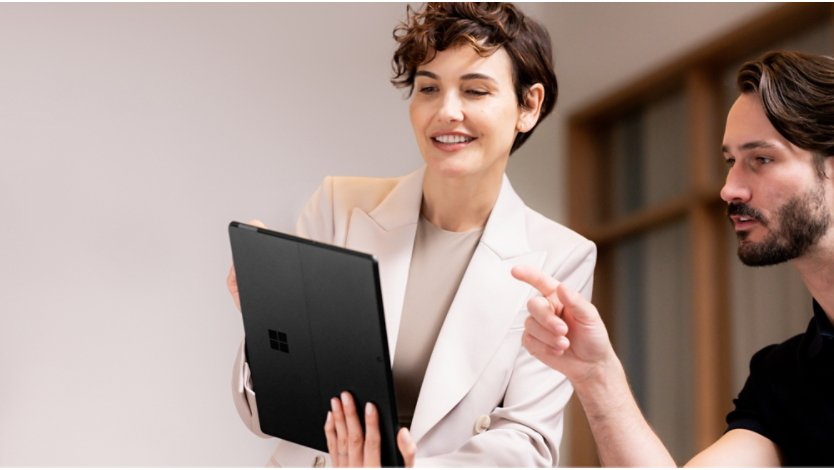 태블릿 모드의 Surface Pro 10 제품을 들여다보는 여성과 남성