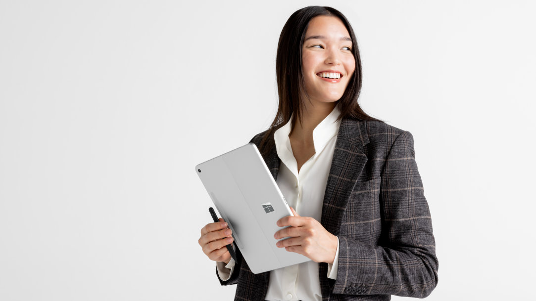 An image of a woman holding a Surface Pro, Copilot+ PC