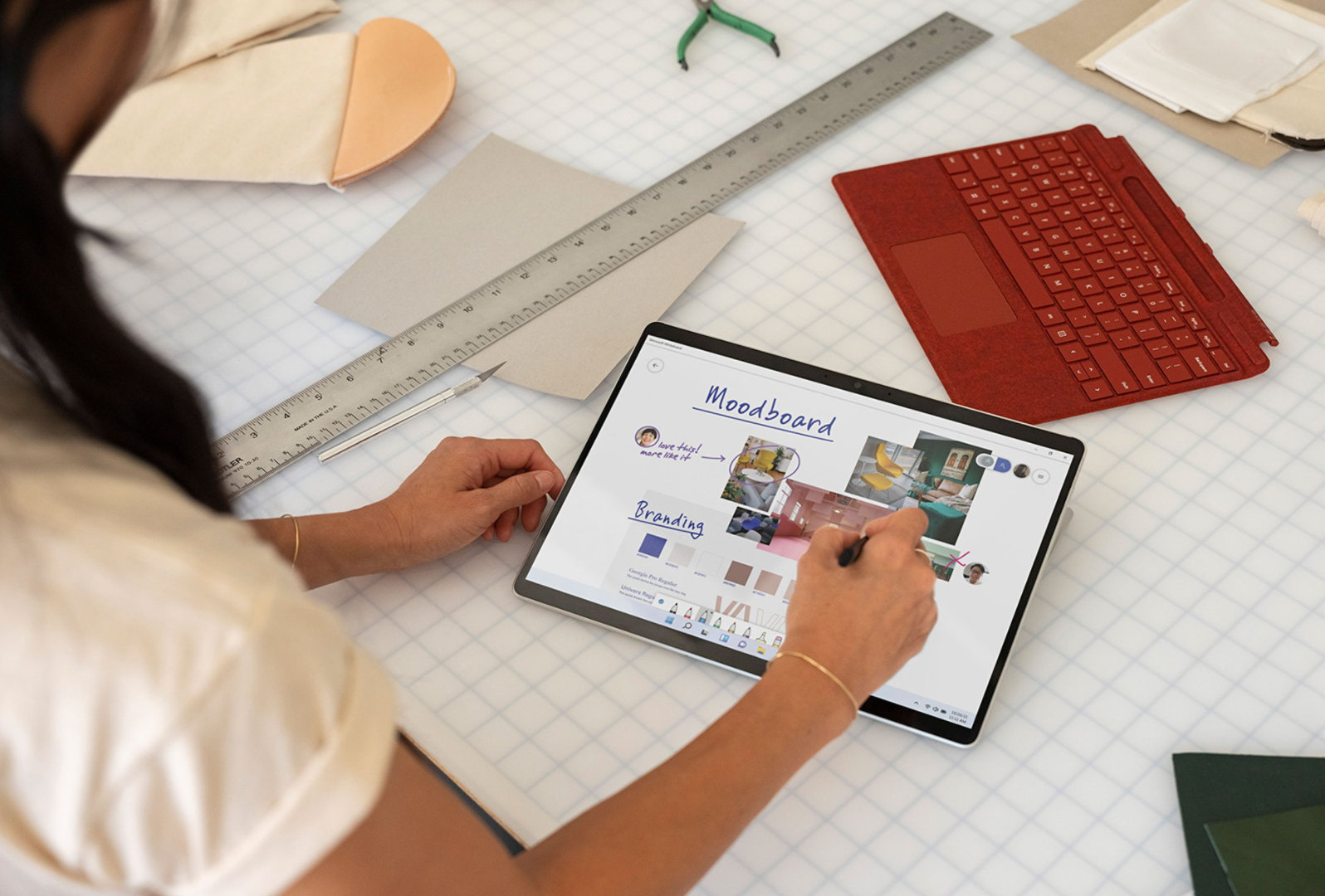A person taking notes on Surface Pro X using Surface Slim Pen 2.