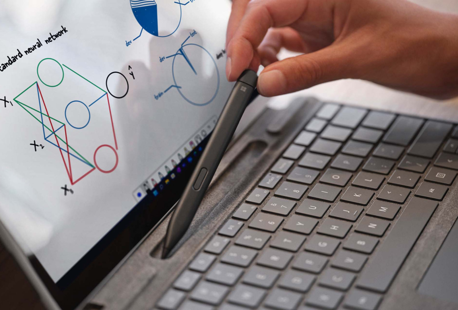 Eine Person platziert einen Surface Slim Pen 2 in der integrierten Aufbewahrung im Surface Pro Signature Keyboard