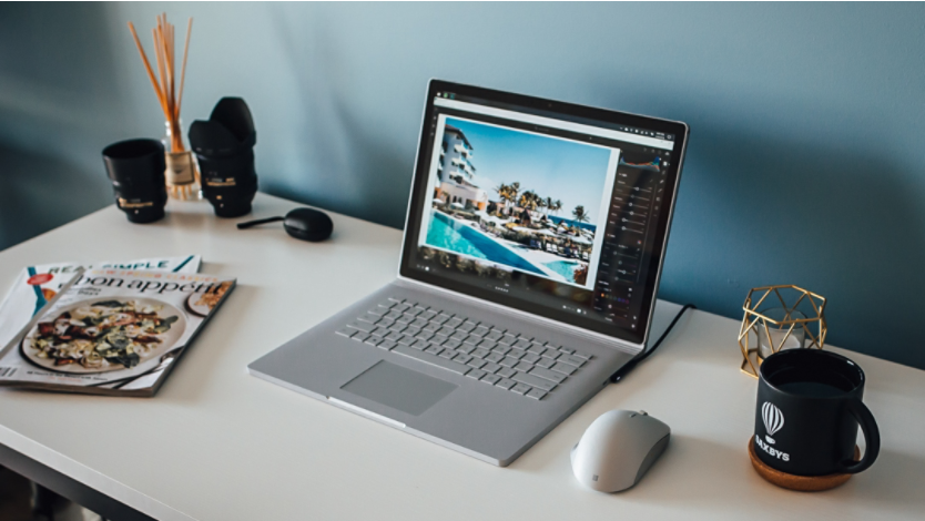 Two people laughing while looking at a Surface laptop