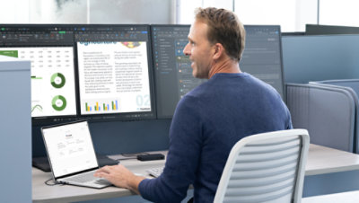 Mies istuu työpöydän ääressä käyttäen Surface Laptopia