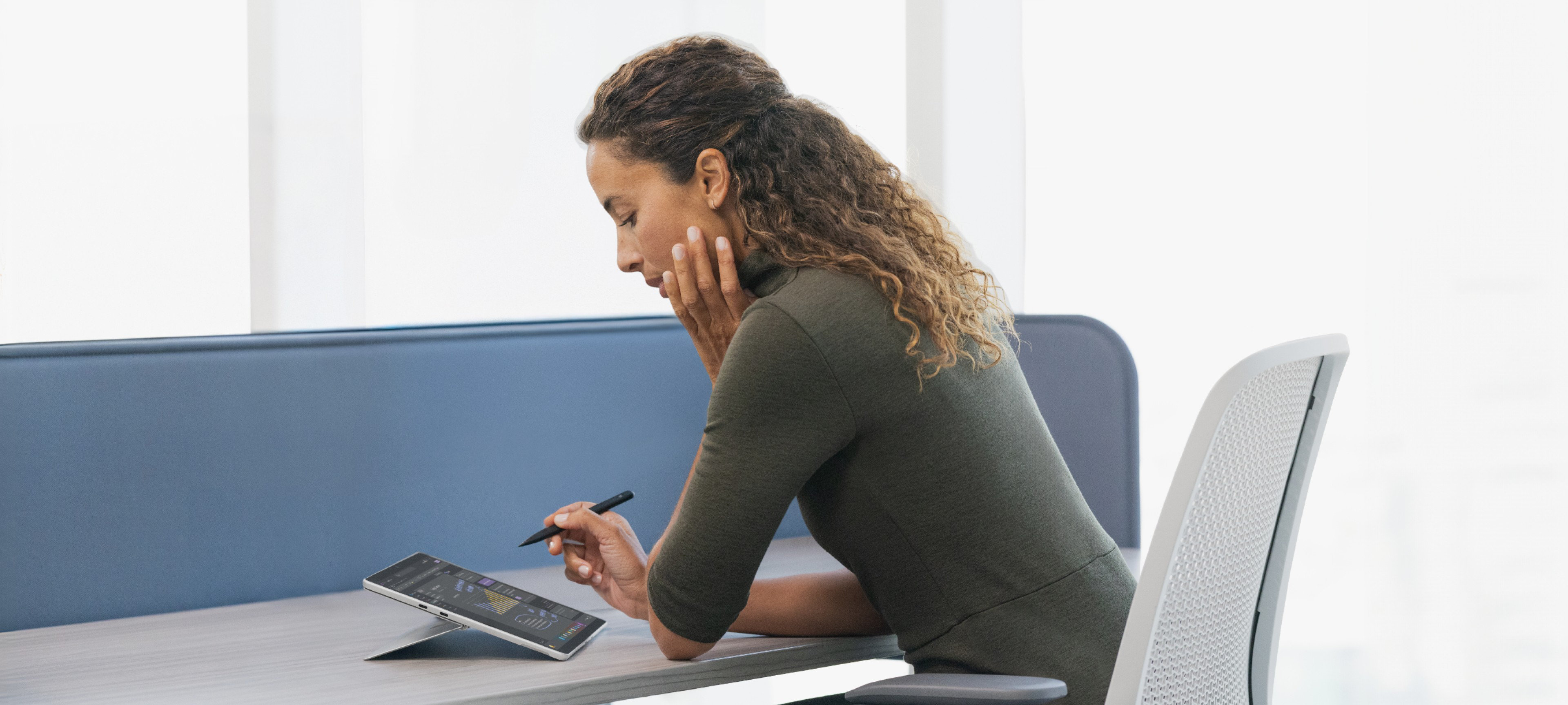 Woman sitting at her office desk using a Surface device