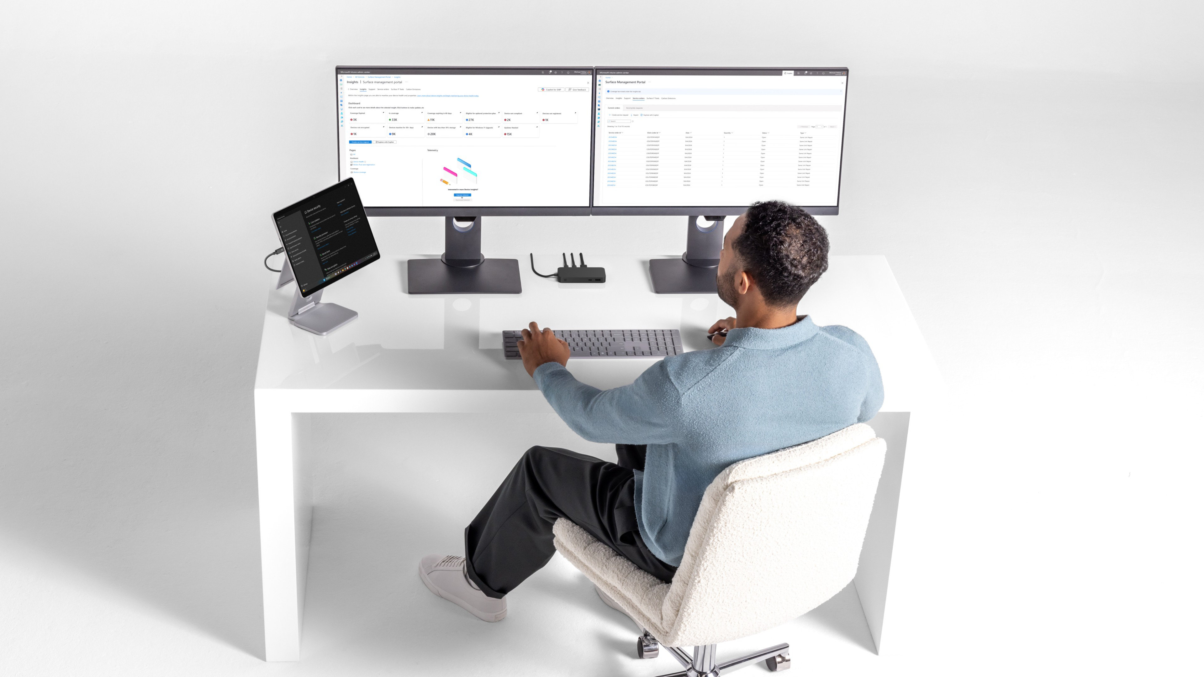 A man sitting at his desk using elevated stand for his Surface device